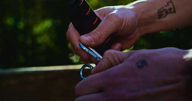 Hands attaching a carabiner, essential for hanging a hammock safely and securely.