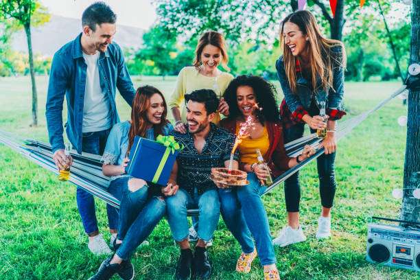 Group of friends enjoying a birthday party among nature hammock
