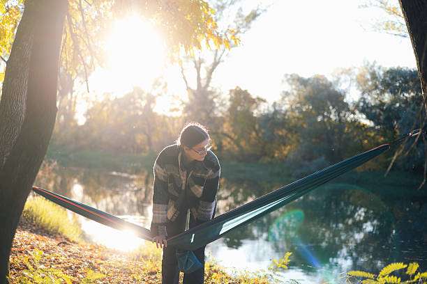 dark green outdoor hammock between autumn trees sun flare durable lifestyle